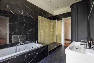 Miniature Location salle Valenciennes (Nord) - Hôtel Particulier Le 119 #22 Salle de bain avec baignoire encastrée, douche à l'italienne, carrelage noir marbré et mosaïque dorée.