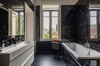Miniature Location salle Valenciennes (Nord) - Hôtel Particulier Le 119 #23 Salle de bain avec baignoire encastrée, douche à l'italienne, carrelage noir marbré et mosaïque dorée.