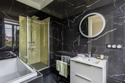 Miniature Location salle Valenciennes (Nord) - Hôtel Particulier Le 119 #27 Salle de bain avec baignoire encastrée, douche à l'italienne, carrelage noir marbré et mosaïque dorée.
