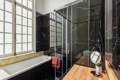 Miniature Location salle Valenciennes (Nord) - Hôtel Particulier Le 119 #31 Salle de bain avec baignoire encastrée, douche à l'italienne, carrelage noir marbré et mosaïque dorée.