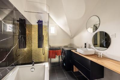 Miniature Location salle Valenciennes (Nord) - Hôtel Particulier Le 119 #39 Salle de bain avec baignoire encastrée, douche à l'italienne, carrelage noir marbré et mosaïque dorée.