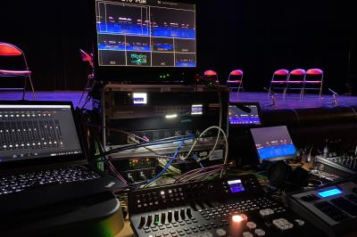 Installation technique avec écrans, projecteurs et équipements audiovisuels dans une salle aux murs clairs.