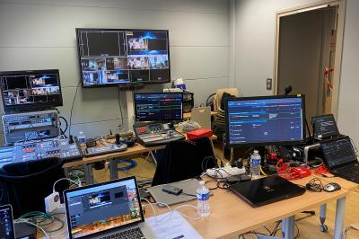 Installation technique avec écrans, projecteurs et équipements audiovisuels dans une salle aux murs clairs.