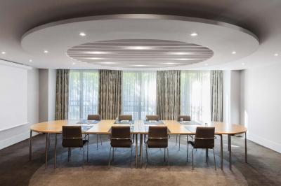 Salle de petit-déjeuner avec buffet varié, tables dressées, éclairage chaleureux et décor moderne en bois sombre.