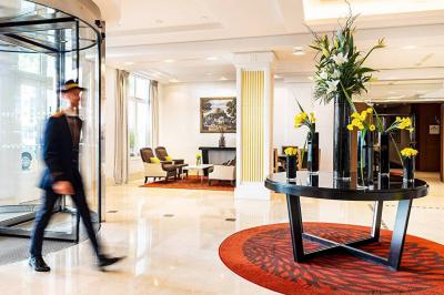 Salle de petit-déjeuner avec buffet varié, tables dressées, éclairage chaleureux et décor moderne en bois sombre.