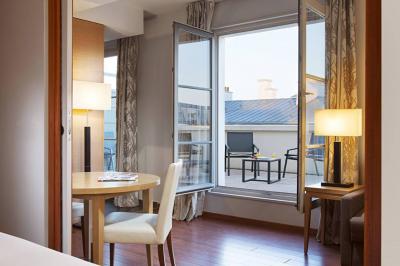 Salle de petit-déjeuner avec buffet varié, tables dressées, éclairage chaleureux et décor moderne en bois sombre.