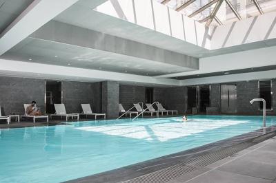 Salle de petit-déjeuner avec buffet varié, tables dressées, éclairage chaleureux et décor moderne en bois sombre.
