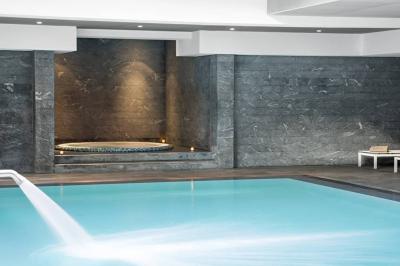 Salle de petit-déjeuner avec buffet varié, tables dressées, éclairage chaleureux et décor moderne en bois sombre.