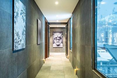 Salle de petit-déjeuner avec buffet varié, tables dressées, éclairage chaleureux et décor moderne en bois sombre.