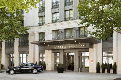 Salle de petit-déjeuner avec buffet varié, tables dressées, éclairage chaleureux et décor moderne en bois sombre.