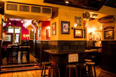 Miniature Location salle Paris 2 (Paris) - Corcoran's Grands Boulevards #4 Façade d'un pub irlandais avec enseignes lumineuses vertes et jaunes, devant un bâtiment en pierre.