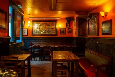 Miniature Location salle Paris 2 (Paris) - Corcoran's Grands Boulevards #6 Façade d'un pub irlandais avec enseignes lumineuses vertes et jaunes, devant un bâtiment en pierre.