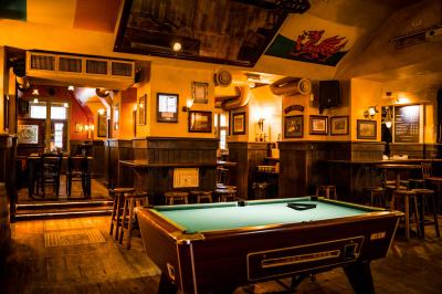 Miniature Location salle Paris 2 (Paris) - Corcoran's Grands Boulevards #1 Façade d'un pub irlandais avec enseignes lumineuses vertes et jaunes, devant un bâtiment en pierre.