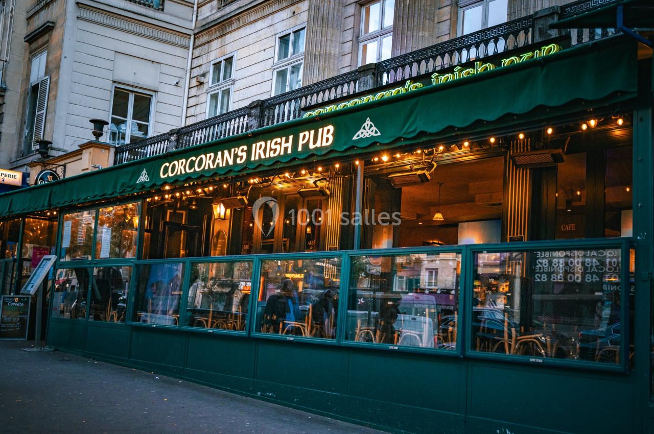 Location salle Paris 2 (Paris) - Corcoran's Grands Boulevards #10 Façade d'un pub irlandais avec une terrasse vitrée, éclairages chaleureux et enseigne ’Corcoran's Irish Pub’.