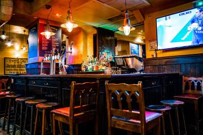 Miniature Location salle Paris 2 (Paris) - Corcoran's Grands Boulevards #8 Façade d'un pub irlandais avec enseignes lumineuses vertes et jaunes, devant un bâtiment en pierre.