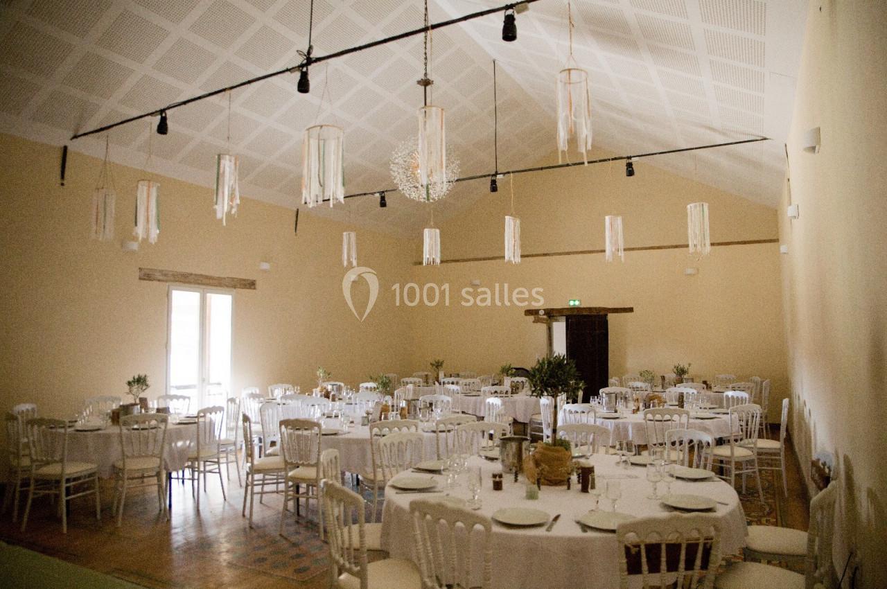 Location salle Wy-dit-Joli-Village (Val-d'Oise) - Château d'Hazeville #14 Salle de réception lumineuse avec des tables rondes dressées, des chaises blanches et des suspensions décoratives.