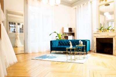 Miniature Via Novias #2 Femme portant une robe de mariée blanche avec un dos ouvert, posant dans un jardin fleuri.