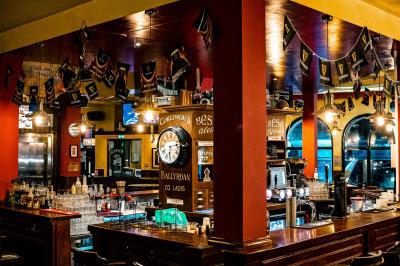 Miniature Location salle Paris 18 (Paris) - Corcoran's Sacré Coeur #4 Façade d'un pub irlandais avec enseignes vertes, drapeau irlandais et arbres aux feuilles d'automne.