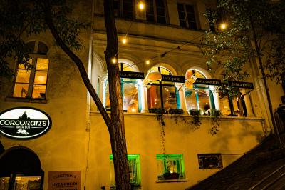 Miniature Location salle Paris 18 (Paris) - Corcoran's Sacré Coeur #5 Façade d'un pub irlandais avec enseignes vertes, drapeau irlandais et arbres aux feuilles d'automne.