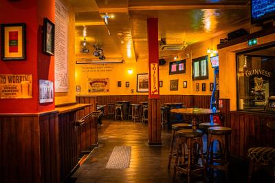 Miniature Location salle Paris 18 (Paris) - Corcoran's Sacré Coeur #7 Façade d'un pub irlandais avec enseignes vertes, drapeau irlandais et arbres aux feuilles d'automne.