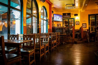 Miniature Location salle Paris 18 (Paris) - Corcoran's Sacré Coeur #11 Façade d'un pub irlandais avec enseignes vertes, drapeau irlandais et arbres aux feuilles d'automne.