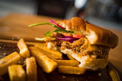 Miniature Location salle Paris 1 (Paris) - Mc Brides #26 Intérieur d'un pub avec des tables en bois, des tabourets, un tableau noir et une ambiance tamisée.