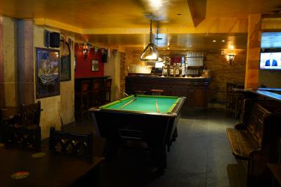 Miniature Location salle Paris 1 (Paris) - Mc Brides #1 Intérieur d'un pub avec des tables en bois, des tabourets, un tableau noir et une ambiance tamisée.