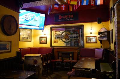 Miniature Location salle Paris 1 (Paris) - Mc Brides #3 Intérieur d'un pub avec des tables en bois, des tabourets, un tableau noir et une ambiance tamisée.