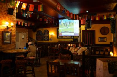 Miniature Location salle Paris 1 (Paris) - Mc Brides #4 Intérieur d'un pub avec des tables en bois, des tabourets, un tableau noir et une ambiance tamisée.