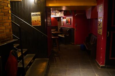 Miniature Location salle Paris 1 (Paris) - Mc Brides #8 Intérieur d'un pub avec des tables en bois, des tabourets, un tableau noir et une ambiance tamisée.