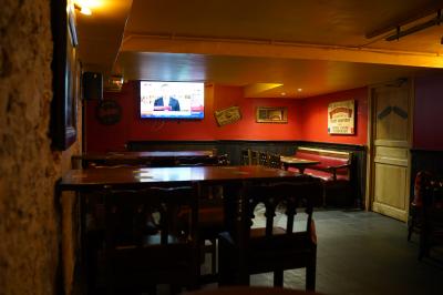 Miniature Location salle Paris 1 (Paris) - Mc Brides #10 Intérieur d'un pub avec des tables en bois, des tabourets, un tableau noir et une ambiance tamisée.