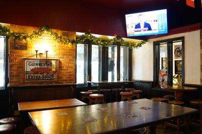 Miniature Location salle Paris 1 (Paris) - Mc Brides #14 Intérieur d'un pub avec des tables en bois, des tabourets, un tableau noir et une ambiance tamisée.