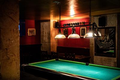 Miniature Location salle Paris 1 (Paris) - Mc Brides #16 Intérieur d'un pub avec des tables en bois, des tabourets, un tableau noir et une ambiance tamisée.