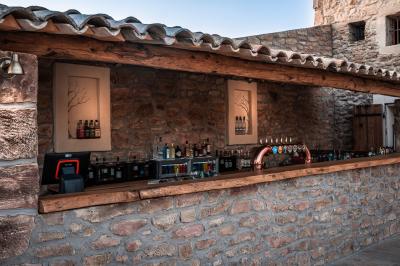 Miniature Location salle Aix-en-Provence (Bouches-du-Rhône) - Maneo #9 Salle rustique avec murs en pierre, tonneaux en bois servant de tables, tabourets métalliques et éclairage chaleureux.