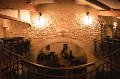 Miniature Location salle Aix-en-Provence (Bouches-du-Rhône) - Maneo #11 Salle rustique avec murs en pierre, tonneaux en bois servant de tables, tabourets métalliques et éclairage chaleureux.