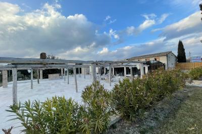 Miniature Location salle Aix-en-Provence (Bouches-du-Rhône) - Maneo #12 Salle rustique avec murs en pierre, tonneaux en bois servant de tables, tabourets métalliques et éclairage chaleureux.