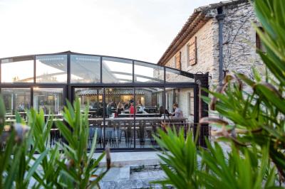 Miniature Location salle Aix-en-Provence (Bouches-du-Rhône) - Maneo #14 Salle rustique avec murs en pierre, tonneaux en bois servant de tables, tabourets métalliques et éclairage chaleureux.