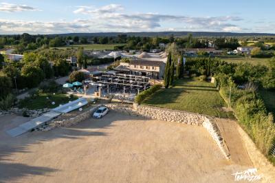 Miniature Location salle Aix-en-Provence (Bouches-du-Rhône) - Maneo #3 Salle rustique avec murs en pierre, tonneaux en bois servant de tables, tabourets métalliques et éclairage chaleureux.