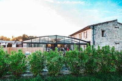 Miniature Location salle Aix-en-Provence (Bouches-du-Rhône) - Maneo #15 Salle rustique avec murs en pierre, tonneaux en bois servant de tables, tabourets métalliques et éclairage chaleureux.