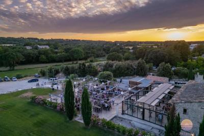 Miniature Location salle Aix-en-Provence (Bouches-du-Rhône) - Maneo #16 Salle rustique avec murs en pierre, tonneaux en bois servant de tables, tabourets métalliques et éclairage chaleureux.