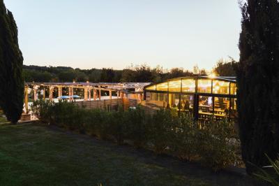 Miniature Location salle Aix-en-Provence (Bouches-du-Rhône) - Maneo #17 Salle rustique avec murs en pierre, tonneaux en bois servant de tables, tabourets métalliques et éclairage chaleureux.