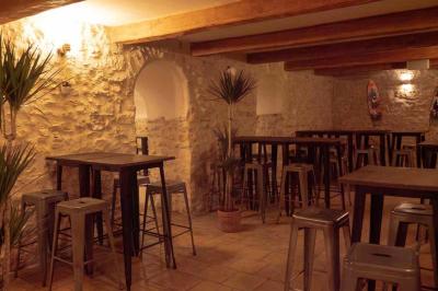 Miniature Location salle Aix-en-Provence (Bouches-du-Rhône) - Maneo #18 Salle rustique avec murs en pierre, tonneaux en bois servant de tables, tabourets métalliques et éclairage chaleureux.