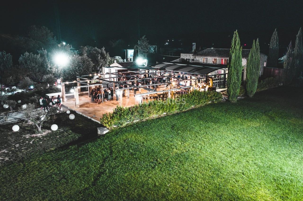 Location salle Aix-en-Provence (Bouches-du-Rhône) - Maneo #2 Vue aérienne nocturne d'un espace événementiel éclairé avec terrasse et pelouse environnante.