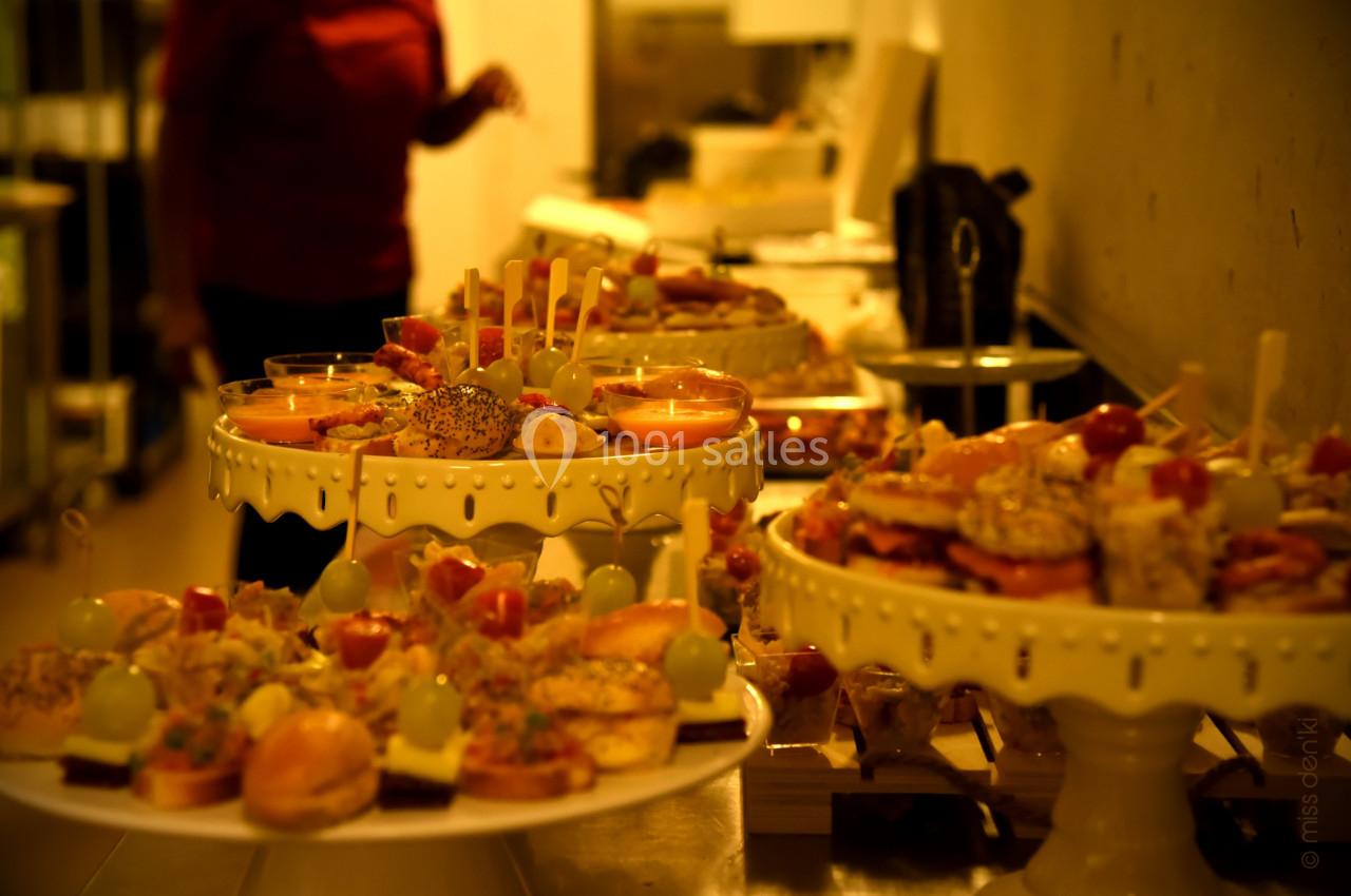 Plateaux de bouchées apéritives variées disposés sur des présentoirs dans un cadre intérieur lumineux.