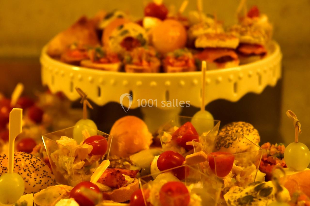 Plateaux de bouchées apéritives variées avec légumes, fromage et pain, présentées sur des supports décoratifs.