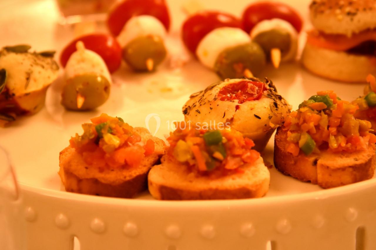 Plateau de bouchées apéritives variées, incluant canapés, brochettes de tomates-mozzarella et verrines.