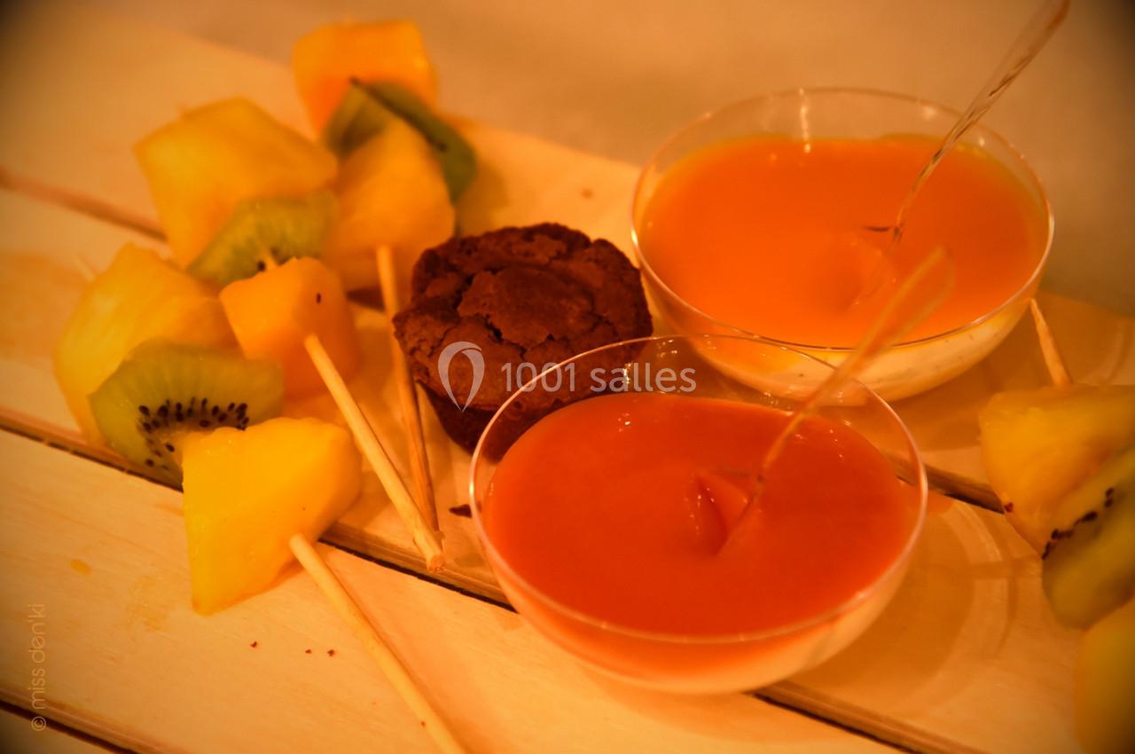 Brochettes de fruits frais avec kiwi et ananas, accompagnées de sauces et d'un petit gâteau au chocolat.