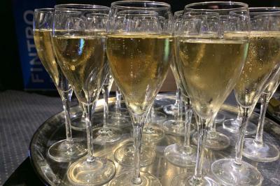 Plateau de verres à pied remplis de champagne pétillant, disposés pour un événement ou une réception.