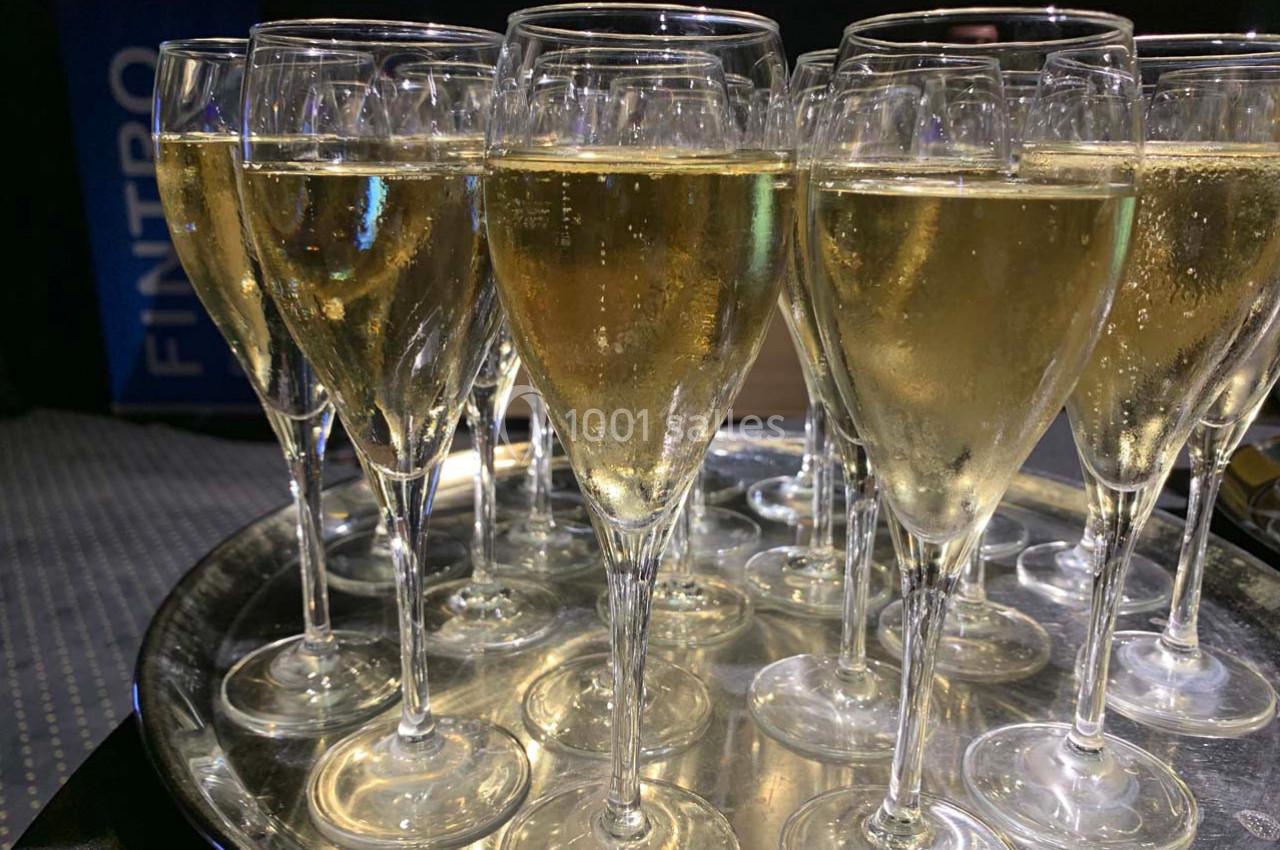 Plateau de verres à pied remplis de champagne pétillant, disposés pour un événement ou une réception.