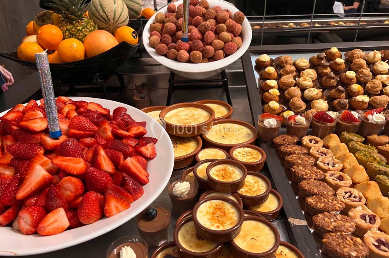 Plateau de desserts variés comprenant fruits frais, crèmes brûlées, pâtisseries et autres douceurs.